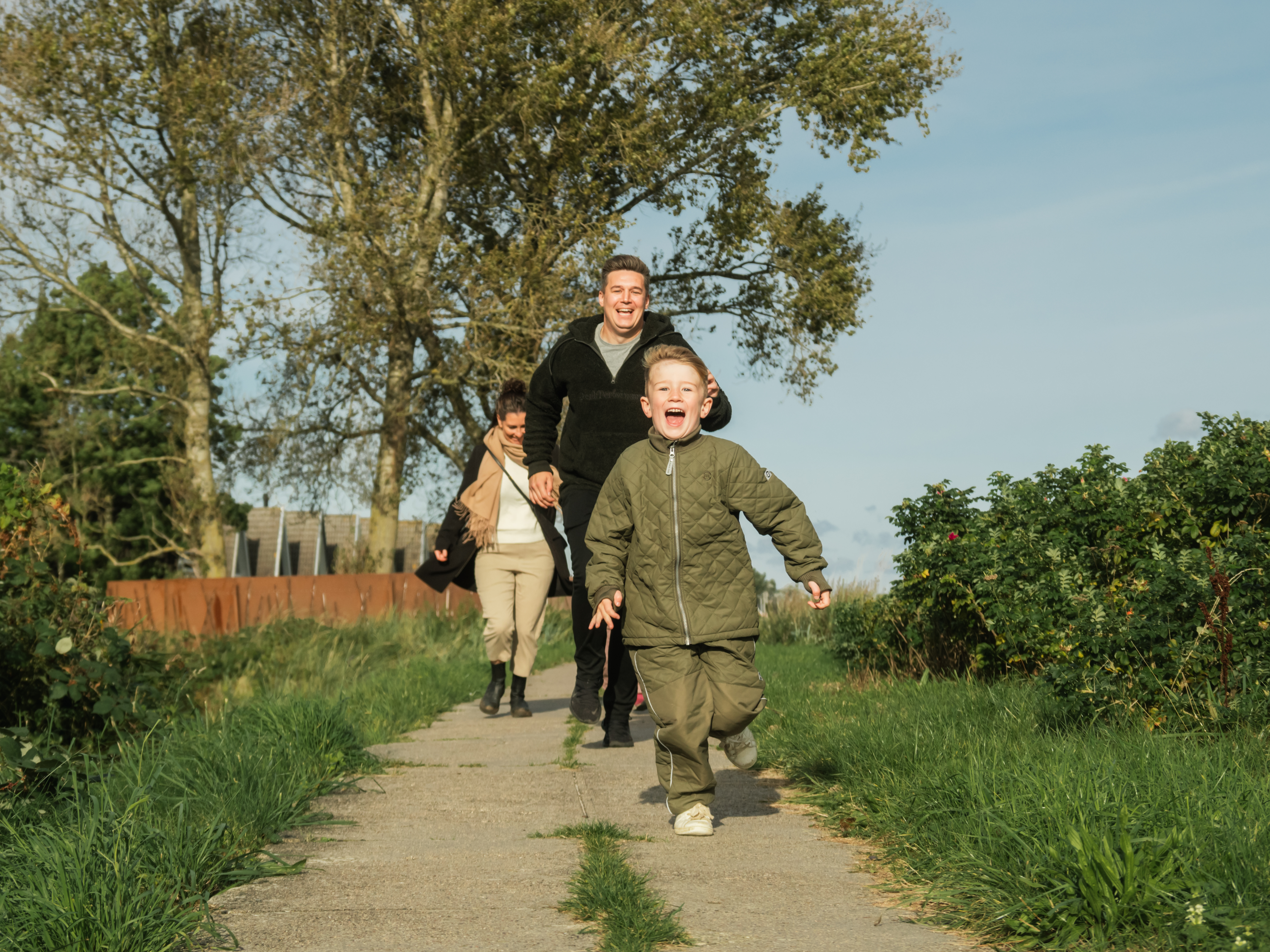 Familie med barn løber på sti